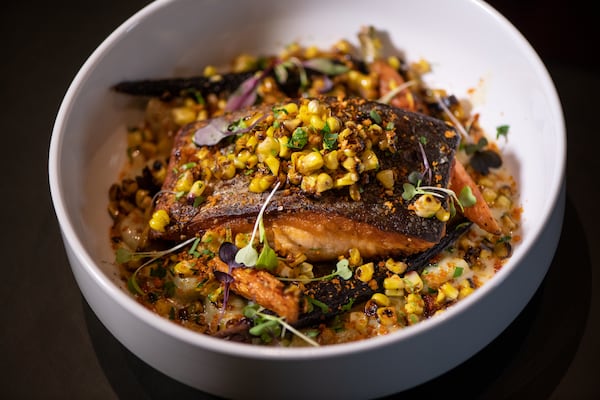 The Continent Atlanta Pan Seared Salmon with Scotch Bonnet Beurre Blanc, callaloo gnocchi, heirloom carrots, and charred corn. (Mia Yakel for The Atlanta Journal-Constitution)