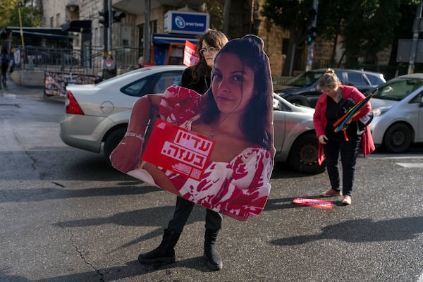 A supporter of Israeli hostages held by Hamas in Gaza, holds a placard showing a loved one with writing: "still in Gaza," during a protest calling for their release outside the prime minister's house in Jerusalem, Monday, Nov. 18, 2024. (AP Photo/Ohad Zwigenberg)