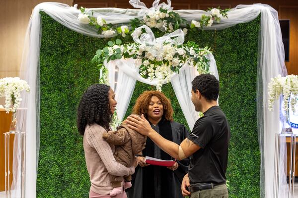 (L-R) Sorrena Freeman and Martin Shook, with their baby Malakiya, are married by Pastor Joc’Quelyn Carter in Courtroom 9G of the Fulton County Courthouse in Atlanta on Valentine’s Day, Tuesday, February 14, 2023. (Arvin Temkar / arvin.temkar@ajc.com)