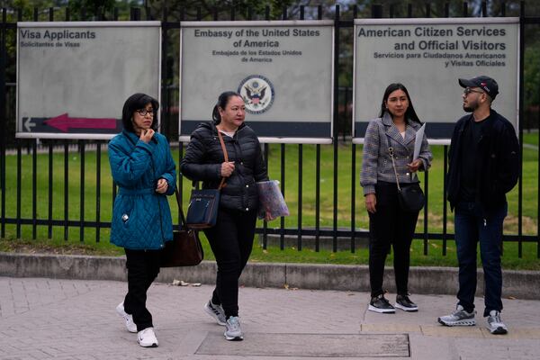 People stand outside the U.S. embassy in Bogota, Colombia, Monday, Jan. 27, 2025, where they were notified their visa appointments were canceled due to Colombian President Gustavo Petro's refusal to accept repatriation flights of Colombian citizens from the United States. (AP Photo/Fernando Vergara)