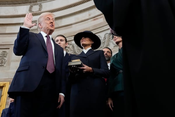 Donald Trump is sworn in as the 47th president of the United States by Chief Justice John Roberts as Melania Trump holds the Bible during the inauguration in the Capitol Rotunda in Washington.