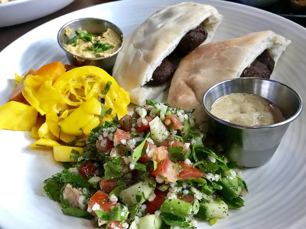 Shade Street Food and Bar puts its own spin on dishes from around the globe. Pictured is the falafel pita — chickpea fritters served in a pita pocket with tabouli, hummus, pickled vegetables and tahini. LIGAYA FIGUERAS / LFIGUERAS@AJC.COM