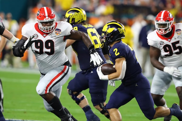 Georgia Bulldogs defensive lineman Jordan Davis (99) pursues  Michigan Wolverines running back Blake Corum (2) and tackles him for a loss in the second quarter. Curtis Compton / Curtis.Compton@ajc.com 