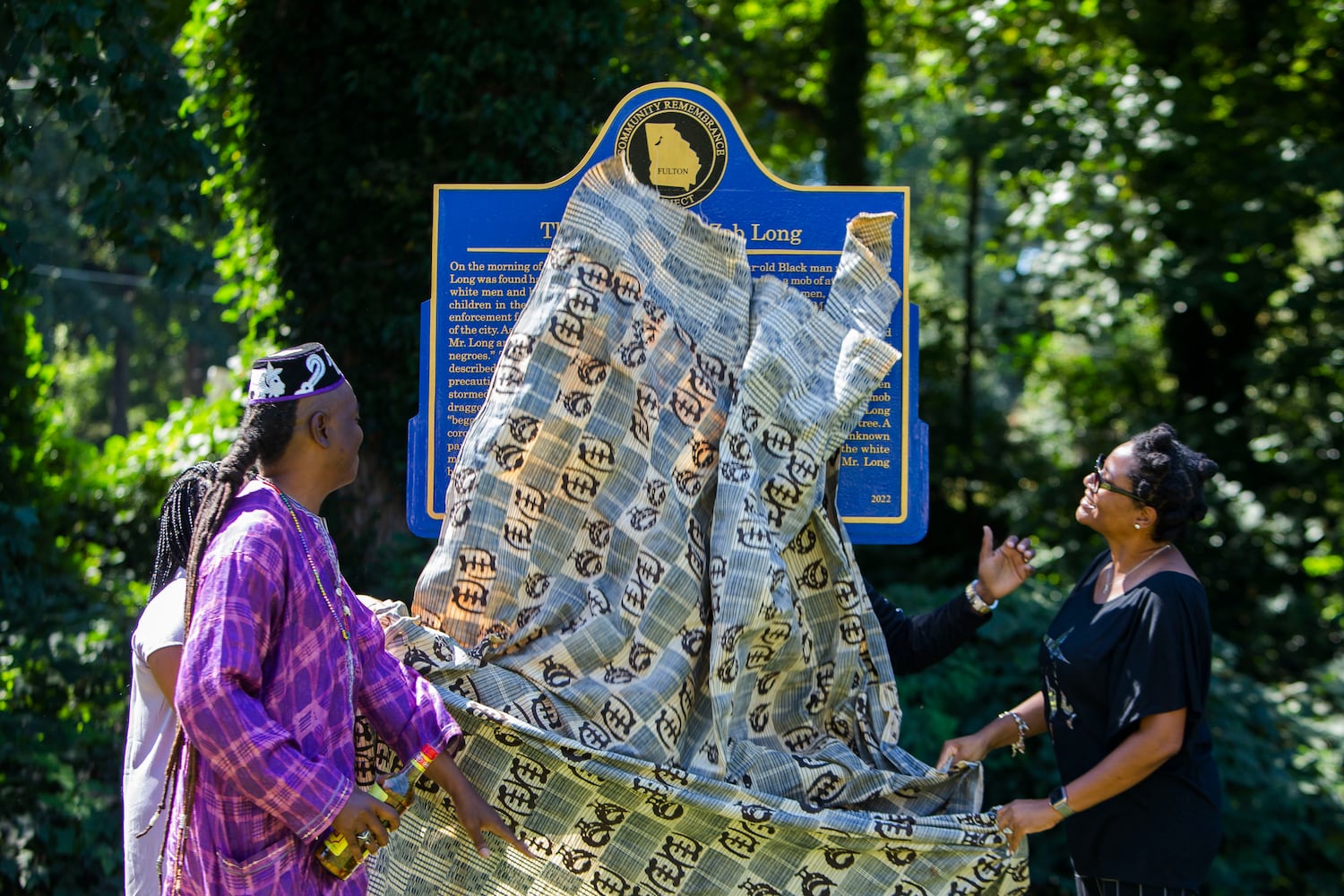 (Left to right) Ann Hill Bond, Christopher Swain and Deana Holiday Ingharam unveil the historical marker for Zeb Long, a lynching victim from the 1906 Atlanta Race Massacre, on Saturday, September 24, 2022, at Sumner Park in East Point, Georgia. The event was held by the Fulton County Remembrance Coalition. CHRISTINA MATACOTTA FOR THE ATLANTA JOURNAL-CONSTITUTION.