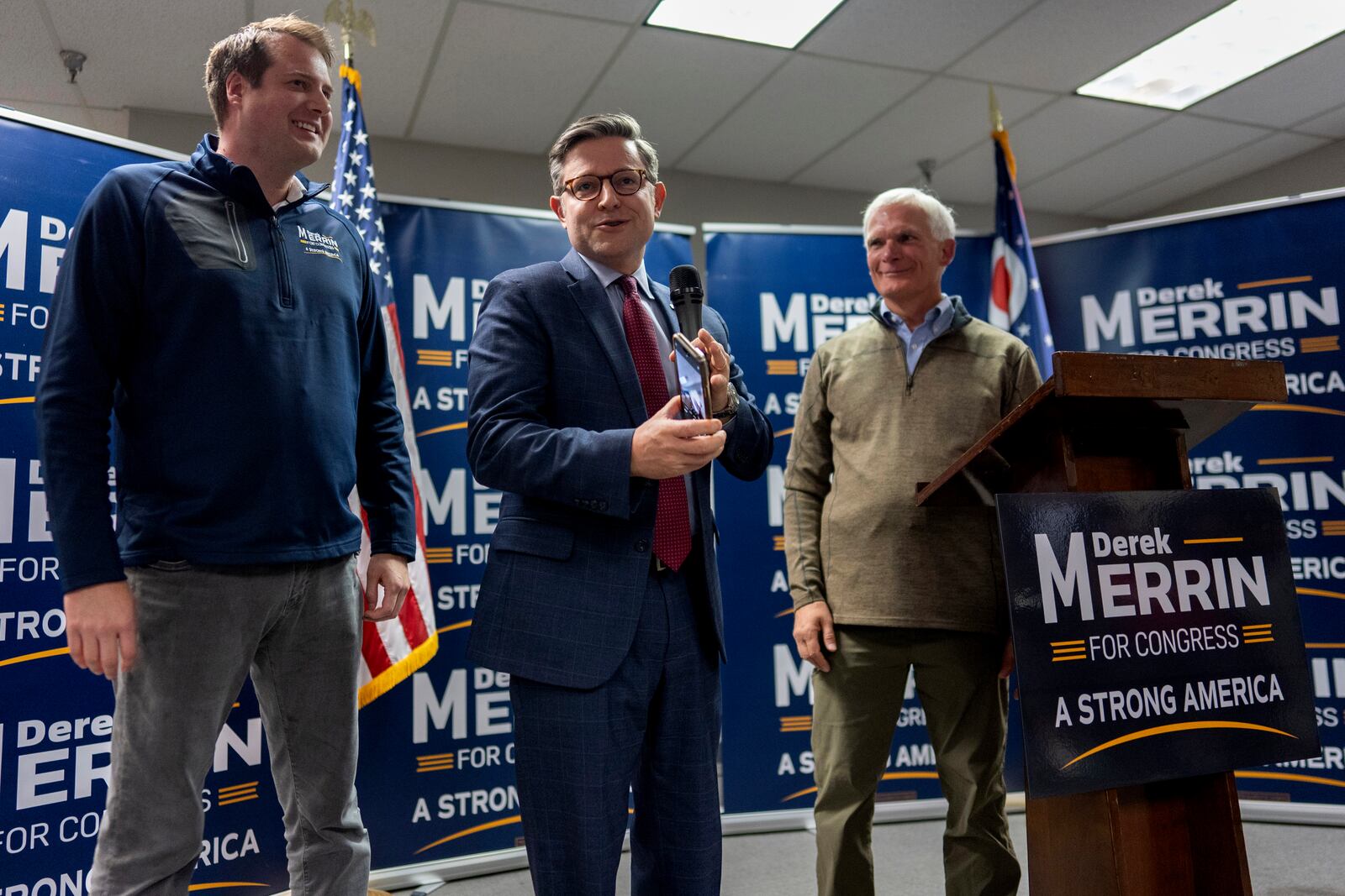 Speaker of the House Mike Johnson, R-La., center, joined by Rep. Bob Latta, R-Ohio, right, and Ohio state Rep. Derek Merrin, speaks during a campaign event at the Lucas County Republican Party headquarters in Holland, Ohio, Saturday, Oct. 26, 2024. (AP Photo/Carolyn Kaster)