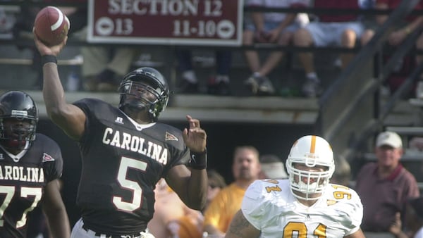 South Carolina's quarterback Dondrial Pinkins (5) throws under preasure from Tennessee's LaRon Harris (91) during the fourth quarter Saturday, Oct. 30, 2004, at Williams-Brice Stadium in Columbia, S.C. Despite a 43-29 loss to Tennessee, Pinkins had a career high 30 of 42 passes for a total of  306 yards.  (Mary Ann Chastain/AP)