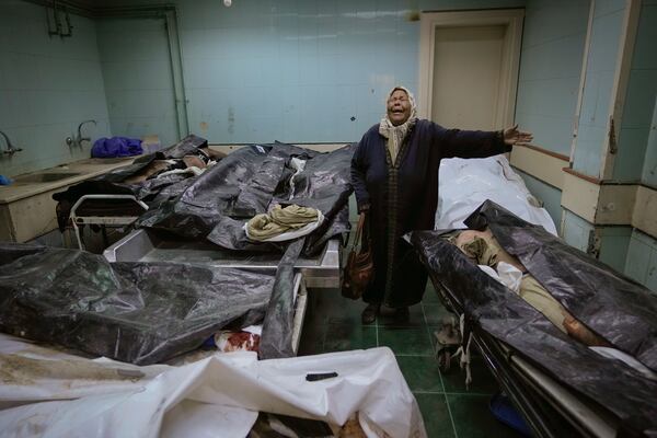 EDS NOTE: GRAPHIC CONTENT - Hilala Meryeh, a 64-year-old Palestinian mother of four, weeps in the middle of the dingy identification room after finding her son's body at the Al-Mojtahed Hospital morgue in Damascus, Syria, on Wednesday, Dec. 11, 2024. Many are flocking to morgues, hoping to identify loved ones who were either killed or imprisoned under President Bashar Assad's government, which collapsed over the weekend. (AP Photo/Hussein Malla)