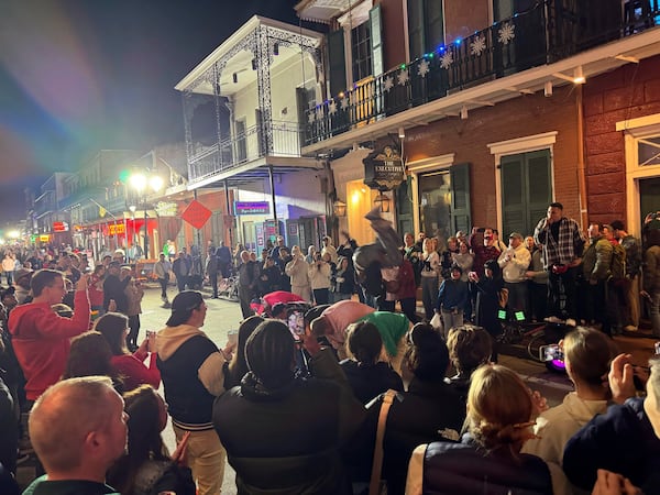 A street performer flips over a line of people on Bourbon street, Thursday, Jan. 2, 2025, after the area reopened to the public following a deadly attack in New Orleans . (AP/Jack Brook)