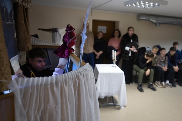 Schoolchildren play a puppet show during opening ceremony for a St. Nicholas Residence and Workshop of Good Deeds in a basement bomb shelter of a military lyceum on World Children's Day in Kyiv, Ukraine, Wednesday, Nov. 20, 2024. (AP Photo/Efrem Lukatsky)