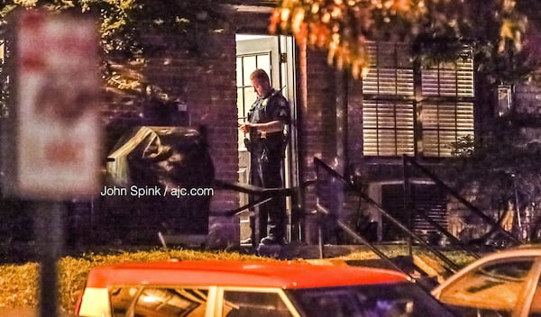 Officers check with neighbors at the Roswell Court Condominiums after a woman was fatally shot Wednesday morning.