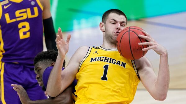 Michigan center Hunter Dickinson (1) grabs a rebound over LSU forward Darius Days, left, during the second half of a second-round game in the NCAA men's college basketball tournament at Lucas Oil Stadium Monday, March 22, 2021, in Indianapolis. (AP Photo/AJ Mast)