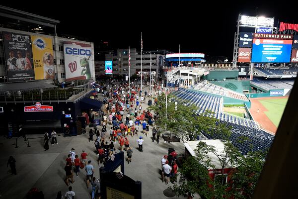 Spectators leave the stadium in the sixth inning of a baseball game between the Washington Nationals and the San Diego Padres, Saturday, July 17, 2021, in Washington. The game was suspended in the sixth inning after police said there was a shooting outside Nationals Park. (AP Photo/Nick Wass)