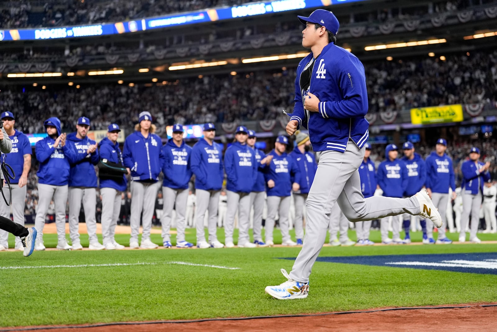 Los Angeles Dodgers' Shohei Ohtani run onto the field for introductions before Game 3 of the baseball World Series against the New York Yankees, Monday, Oct. 28, 2024, in New York. (AP Photo/Ashley Landis)