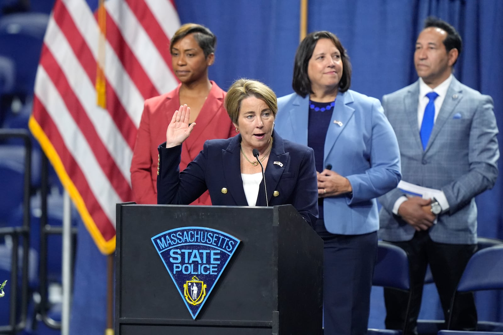 Massachusetts Gov. Maura Healey, front, swears in the 90th Recruit Training Group of the Massachusetts State Police, Wednesday, Oct. 9, 2024, during ceremonies at the DCU Center, in Worcester, Mass., as Mass. Attorney General Andrea Campbell, left, and Mass. Lt. Gov. Kim Driscoll, second from right, look on. (AP Photo/Steven Senne)