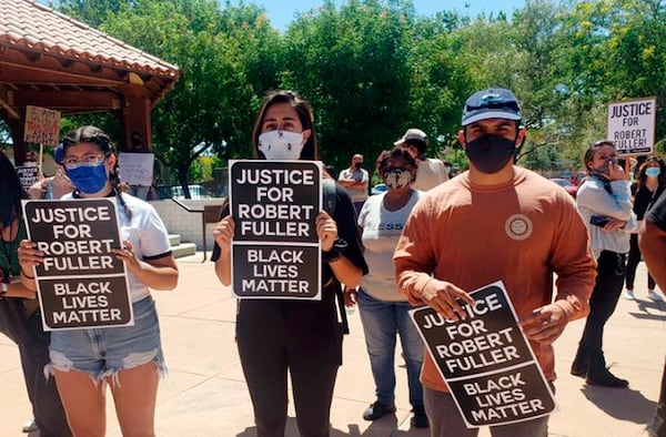 In this Saturday, June 13, 2020, photo provided by Najee Ali, people gather around the park where the body of Robert Fuller was found dead Wednesday, June 10 in Poncitlan Square in Palmdale, Calif. People marched to demand an investigation into the death of 24-year-old Robert Fuller, who was found hanging from a tree early Wednesday near City Hall. The protesters marched from where the body was found to a sheriff's station, with many carrying signs that said "Justice for Robert Fuller."