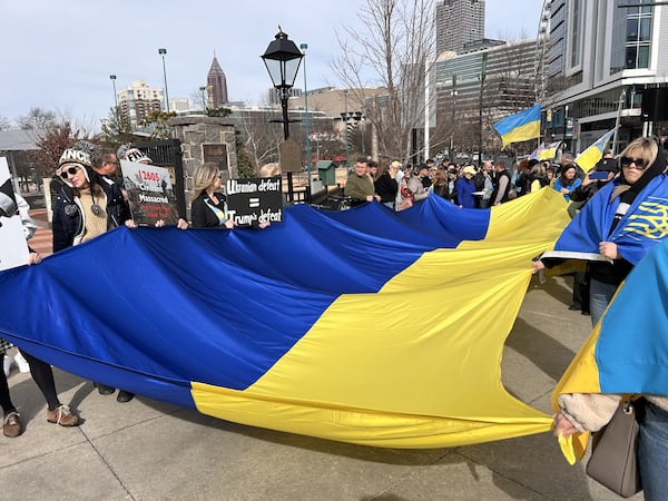 Protesters carry a large Ukrainian flag at Centennial Olympic Park Sunday, nearly three years after Russia launched a full-fledged attack on Ukraine. (Courtesy of Maxim Poliashenko)