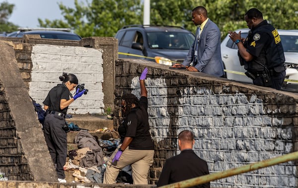 Police investigate the scene where a man was found beaten to death in downtown Atlanta on June 18.