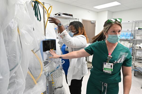 Respiratory Therapist Amber Dixon, right, shows a ventilator as Registered ICU Nurse Kamika Shivers helps at Memorial Health’s Heart and Vascular Institute in Savannah. Respiratory therapists like Dixon are in particularly high demand during this COVID-19 surge. (Hyosub Shin / Hyosub.Shin@ajc.com)