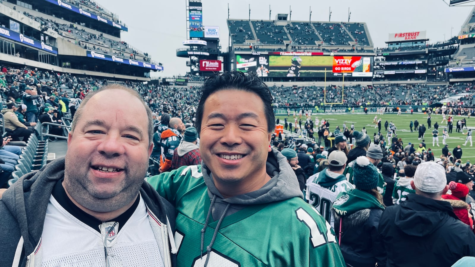 Walt Gebelein and Michael Lo pose at a Philadelphia Eagles game.