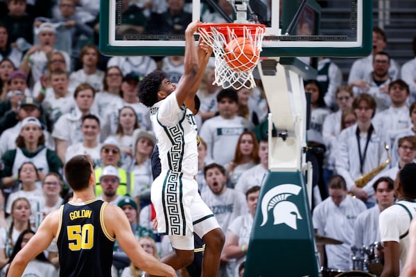 Michigan State guard Jase Richardson, center, dunks against Michigan center Vladislav Goldin (50) during the first half of an NCAA college basketball game, Sunday, March 9, 2025, in East Lansing, Mich. (AP Photo/Al Goldis)