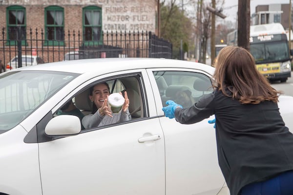 Rachel Jimenez catches a roll of toilet tissue from Trevelino/Keller marketing firm co-founder Genna Keller. ALYSSA POINTER/ALYSSA.POINTER@AJC.COM