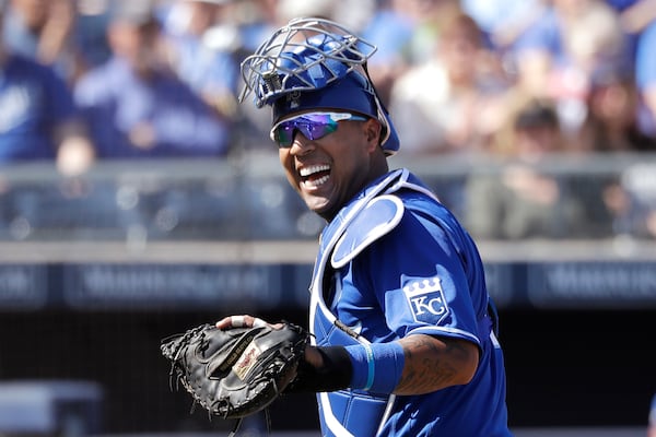 FILE - In this Wednesday, March 4, 2020, file photo, Kansas City Royals catcher Salvador Perez smiles as he turns to a teammate who made an out on a difficult play against the San Diego Padres in the first inning during a spring training baseball game in Peoria, Ariz. (AP Photo/Elaine Thompson, File)