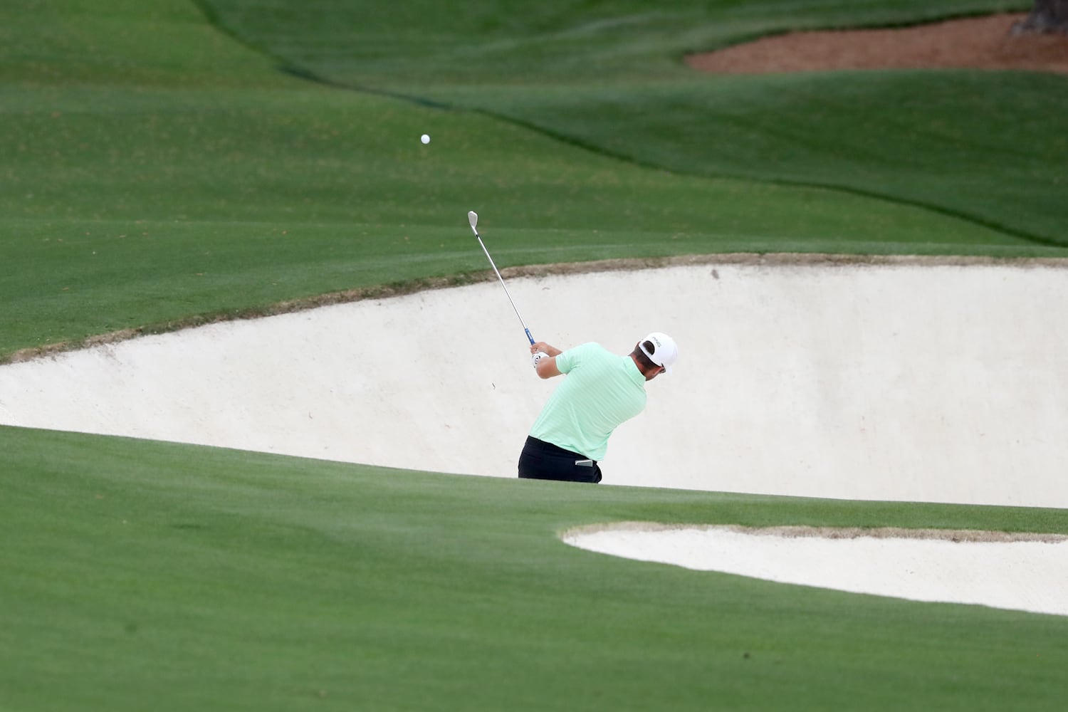 April 10, 2021, Augusta: Corey Conners hits out of the bunker on the eighth hole during the third round of the Masters at Augusta National Golf Club on Saturday, April 10, 2021, in Augusta. Curtis Compton/ccompton@ajc.com