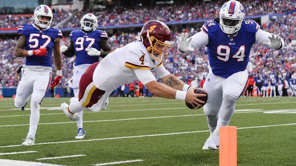 Washington Football Team quarterback Taylor Heinicke (4) dives past Buffalo Bills' Vernon Butler (94) for a touchdown as Bills' A.J. Epenesa (57) and Mario Addison (97) watch during the first half Sunday, Sept. 26, 2021, in Orchard Park, N.Y. (Adrian Kraus/AP)