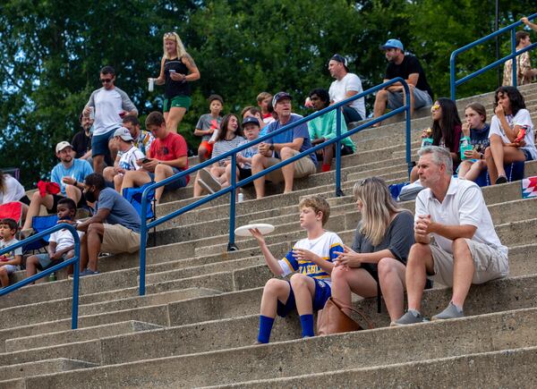 Fans of the Hustle, Atlanta's American Ultimate Disc League team, including Zach Ohnstad (spinning a disc), 14, who plays ultimate himself, watch the professionals win against Philadelphia 24-17 at St. Pius X High School Field on Saturday, June 26, 2021.  (Jenni Girtman for The Atlanta Journal-Constitution)