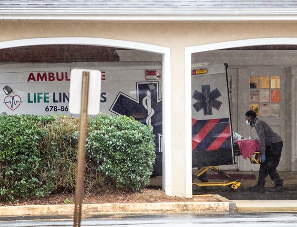 An ambulance driver delivers a patient to the Rosemont at Stone Mountain senior living facility on Thursday. The facility, which experienced problems witnessed by an inspector in December, reported 21 COVID-19 deaths to the state’s daily public case-tracker in a single day. That number, its executive director said, covered the entire pandemic. (Jenni Girtman for The Atlanta Journal-Constitution)