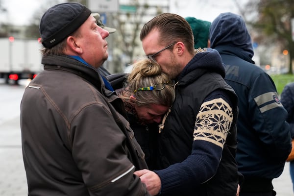 People embrace as they mourn the victims near the Christmas Market, where a car drove into a crowd on Friday evening, in Magdeburg, Germany, Sunday, Dec. 22, 2024. (AP Photo/Ebrahim Noroozi)