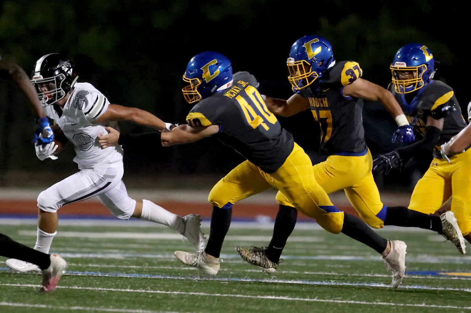 Alpharetta running back Jake Gil (26) runs against Chattahoochee defenders Peter McVay Jr. (40), Gustavo felucca (37), and Matthew Stephen (22) in the second half at Chattahoochee high school Friday, September 25, 2020 in Johns Creek, Ga.. Jlpharetta won 21-7. JASON GETZ FOR THE ATLANTA JOURNAL-CONSTITUTION