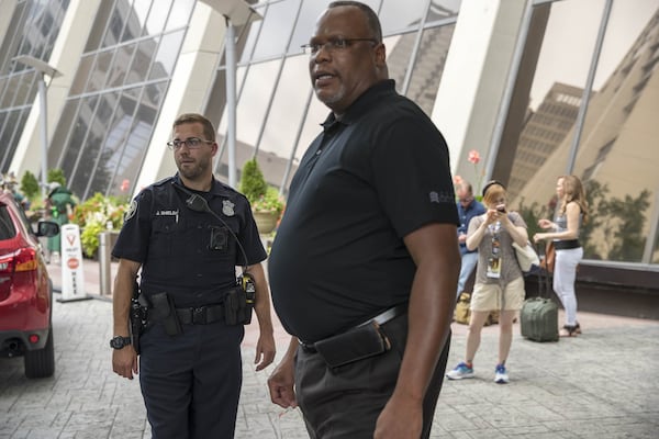 08/30/2018 — Atlanta, Georgia — Atlanta Police Officer Joshua Shields (left) surveys the outside of the Atlanta Hilton Hotel in downtown Atlanta. (ALYSSA POINTER/ALYSSA.POINTER@AJC.COM)