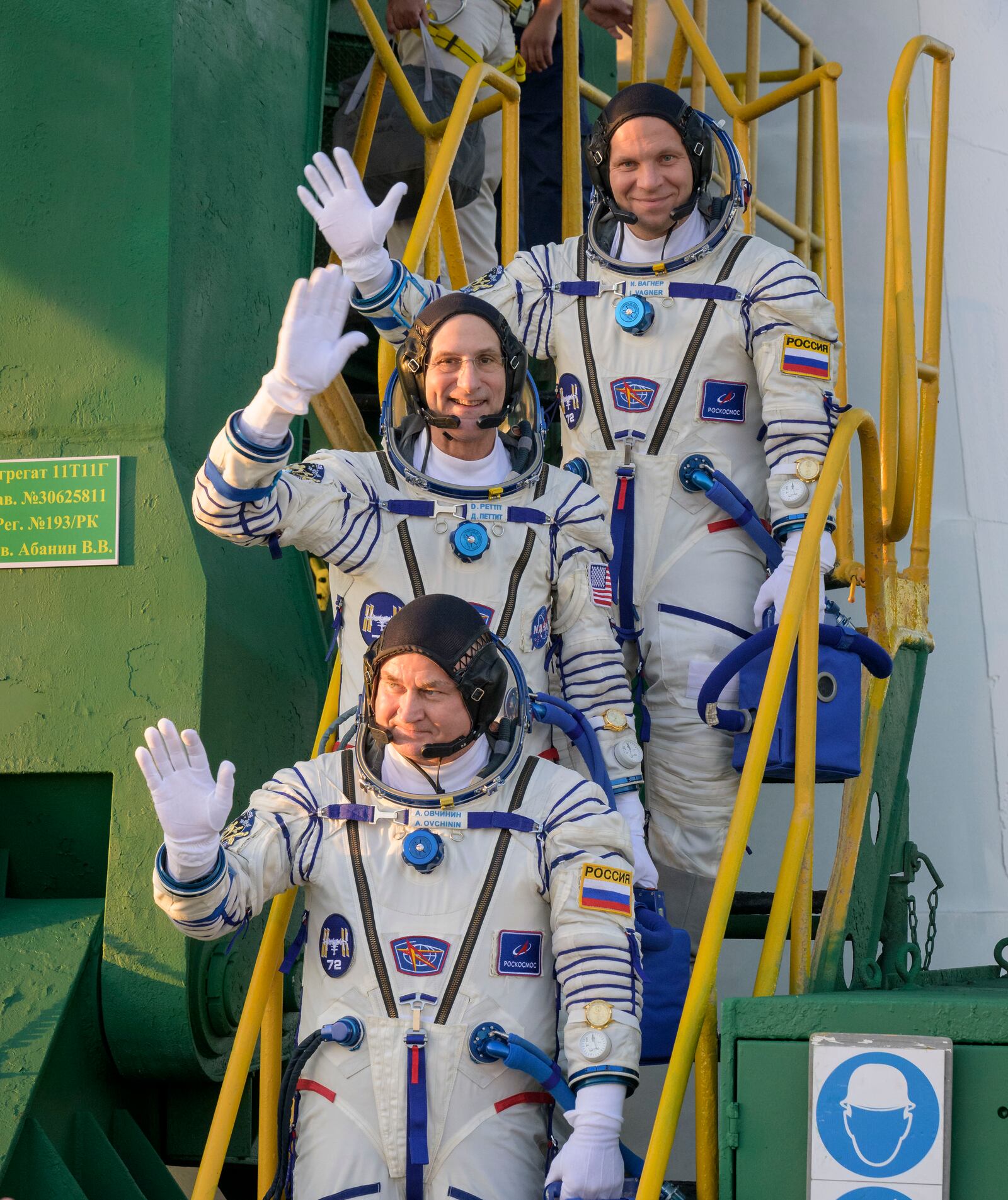 In this image provided by NASA, Expedition 72 crew members: Roscosmos cosmonaut Ivan Vagner, top, NASA astronaut Don Pettit, center, and Roscosmos cosmonaut Alexey Ovchinin, wave farewell prior to boarding the Soyuz MS-26 spacecraft for launch, Wednesday, Sept. 11, 2024 at the Baikonur Cosmodrome in Kazakhstan. Launch of the Soyuz rocket will send the trio on a mission to the International Space Station. (Bill Ingalls/NASA via AP)