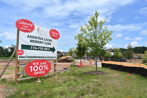 This sign outside Tranquil Gardens Assisted Living & Memory Care went up earlier this year, announcing it was 100% open, despite state COVID restrictions still in place that restricted visitors. An AJC examination found that almost from the time the first residents moved in late in 2018, Tranquil Gardens was scrambling to stay afloat. (Hyosub Shin / Hyosub.Shin@ajc.com)