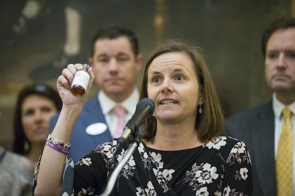 Shannon Cloud, the parent of a child who suffers from seizures, holds up a bottle of THC oil during a press conference in the rotunda of the Georgia State Capitol building in Atlanta on February 14, 2019. Cloud was surrounded by other families and lawmakers as they proposed a law that would grant the legalization of growing and distributing medical marijuana to registered patients. (ALYSSA POINTER/ALYSSA.POINTER@AJC.COM)