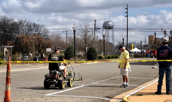 Contractors with Plains public works repaint lines on Main Street.