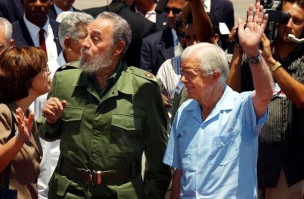 Former Jimmy Carter waves goodbye as he walks with Castro at Jose Marti Airport after a week-long visit to Cuba in 2002.