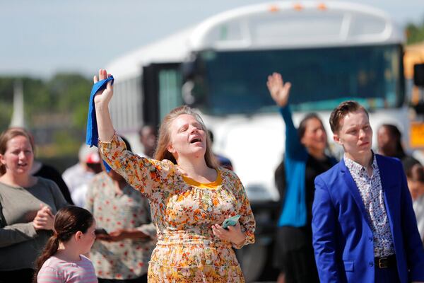 Members of the Life Tabernacle Church sing spiritual songs and hold their hands in the air as they wait for pastor Tony Spell to leave the East Baton Rouge Parish jail in Baton Rouge, La., Tuesday, April 21, 2020. Louisiana authorities arrested the pastor on an assault charge on Tuesday after he admitted that he drove his church bus toward a man who has been protesting his decision to hold mass gatherings in defiance of public health orders during the coronavirus pandemic. (AP Photo/Gerald Herbert)