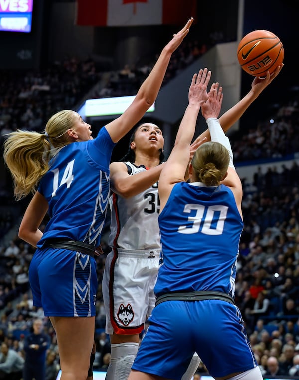 UConn guard Azzi Fudd shoots between Creighton forward Mallory Brake (14) and guard Morgan Maly (30) in the first half of an NCAA college basketball game, Thursday, Feb. 27, 2025, in Hartford, Conn. (AP Photo/Jessica Hill)