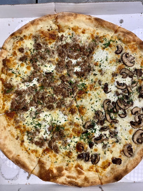 Glide Pizza’s garlic pies are made with garlic, mozzarella, Parmesan, olive oil and parsley — no sauce. We added sausage and mushrooms.
Wendell Brock for The Atlanta Journal-Constitution