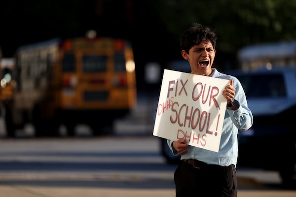 Druid Hills sophomore Santiago Gonzalez-Cassavoy holds a sign reading, “Fix Our School!” outside of a DeKalb County school board meeting in Stone Mountain, Georgia, on April 18, 2022. (Jason Getz / Jason.Getz@ajc.com)