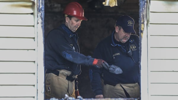 Forest Park fire investigators, Capt. Sam Batten (left) and Major David Haltom (right) investigate the scene of a fatal Clayton County house fire early Thursday. The man who died in the blaze he rescued five children. His name has not been released, but neighbors said he was a hero. (JOHN SPINK/JSPINK@AJC.COM)