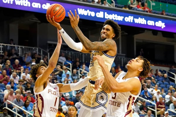 Georgia Tech forward Javon Franklin (4) drives between Florida State guard Jalen Warley (1) and Cam Corhen (3) during the second half of an NCAA college basketball game at the Atlantic Coast Conference Tournament in Greensboro, N.C., Tuesday, March 7, 2023. (AP Photo/Chuck Burton)