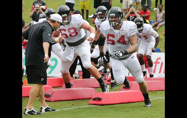 Offensive guards Mike Person (left) and Jared Smith (right) run agility drills during team practice Tuesday in Flowery Branch. Curtis Compton/www.ajc.com