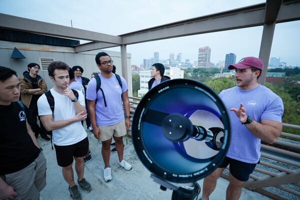 Ethan Atkinson (right), president of Georgia Tech Astronomy Club, speaks to club members as he shows the new telescope that the school acquired for the astrophysics lab Monday. For the eclipse viewing trip, the club plans to bring along astrophotography gear and an 8-inch Celestron telescope with a solar filter for members to use. 
