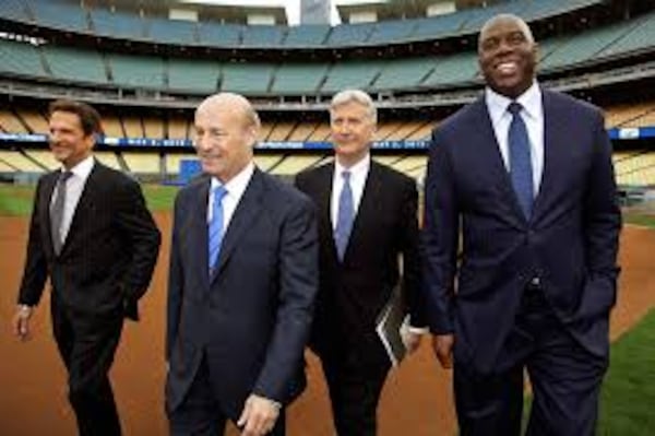  Stan Kasten (second from left) with other Dodgers owners, including Magic Johnson. (AP photo)