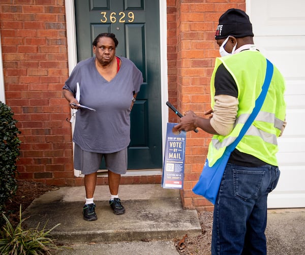 Jenjins Kologbo talks to Angela Alford while canvassing in a Scottdale neighborhood in December 2020  STEVE SCHAEFER FOR THE ATLANTA JOURNAL-CONSTITUTION