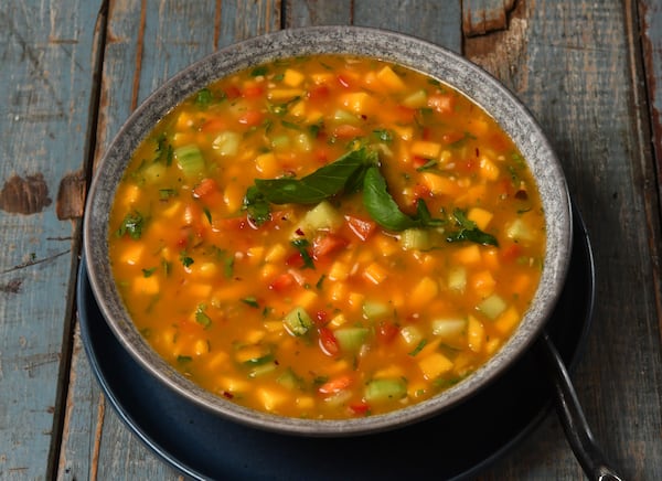 For a refreshing summer dish, you can make Mango-Zpacho, shown here with basil leaf garnish. (Styling by Claudine Molson-Sellers / Chris Hunt for the AJC)