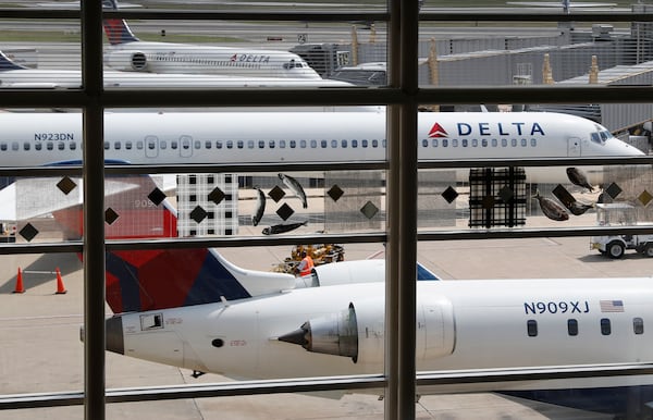 FILE - In this Monday, Aug. 8, 2016, file photo, Delta Air Lines planes are parked at Ronald Reagan Washington National Airport, in Washington.  (AP Photo/Carolyn Kaster, File)